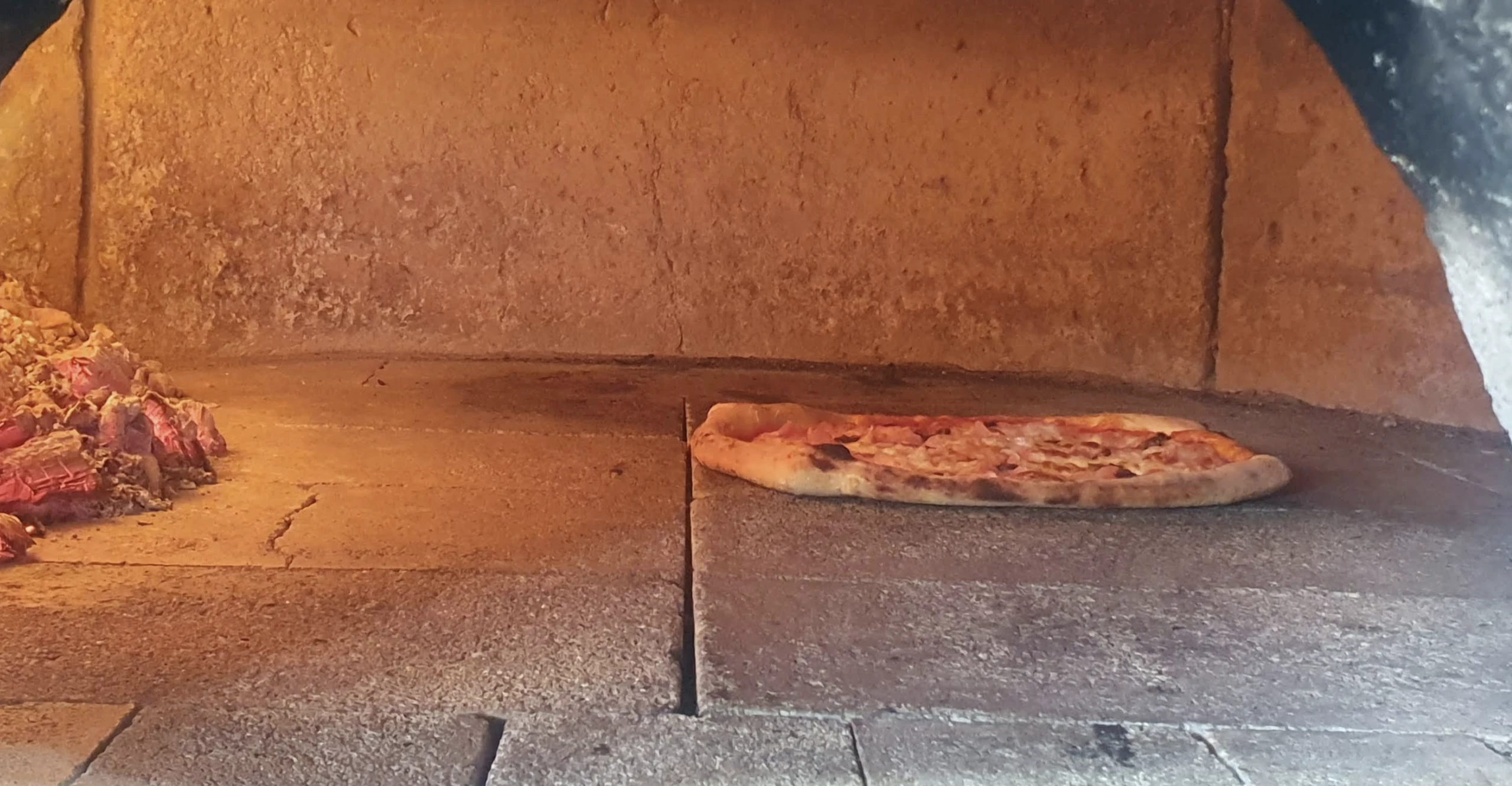 Pizza wypiekana w piecu opalanym drewnem w pizzerii w Jantarze